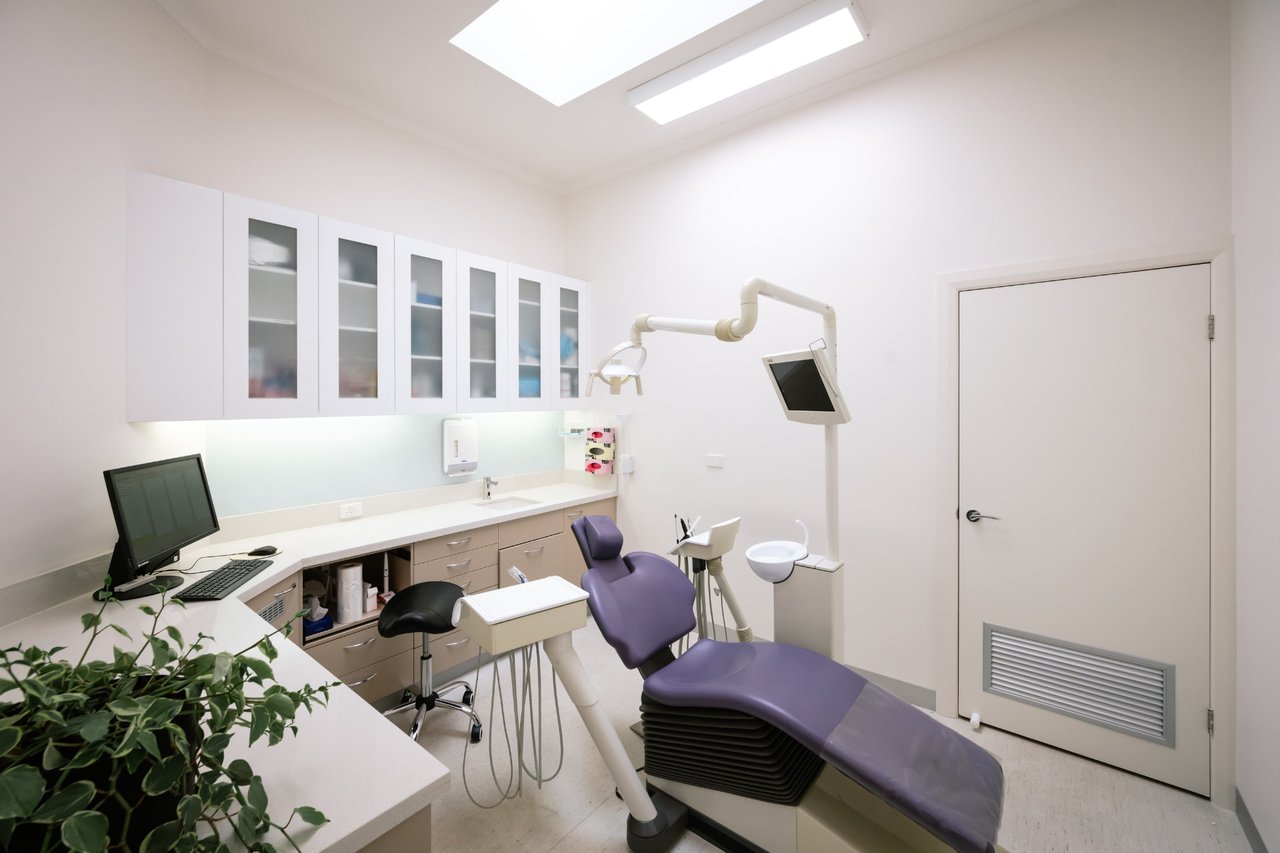 A treatment room at Flinders Dental Practice, with a dental chair, white cabinets and a skylight
